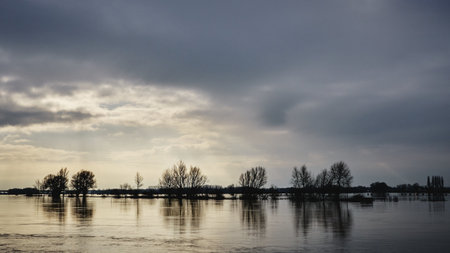 A mesmerizing view of a calm lake under a cloudy skyの写真素材
