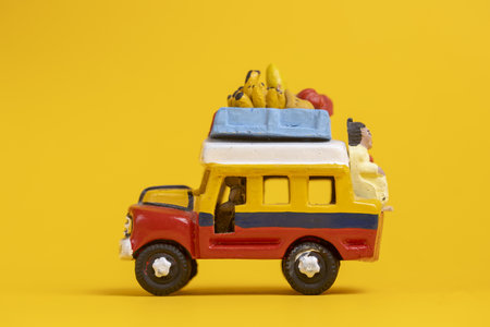 Side view of toy car vehicle with passenger on the back of colorful Colombia themed bus.の写真素材