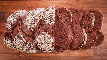 An overhead shot of sliced chocolate challah on a wooden table in a bakeryの写真素材