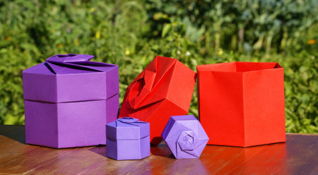 A closeup of red and purple origami craft boxes on a wooden table