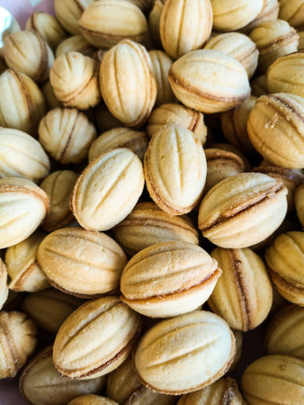 A vertical shot of yummy cookies in nuts form with condensed milkの写真素材