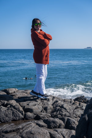 young woman smiling on vacation at the beach on a sunny day vertical photoの写真素材