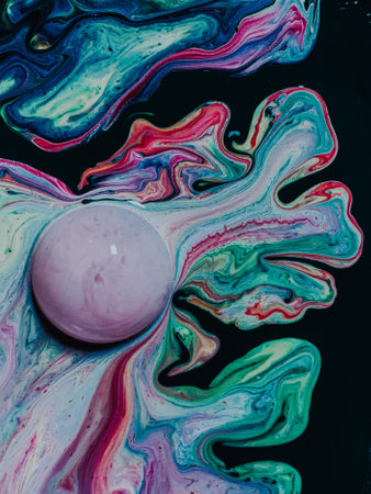 A closeup of a bath bomb with colorful mixed stains in the waterの写真素材