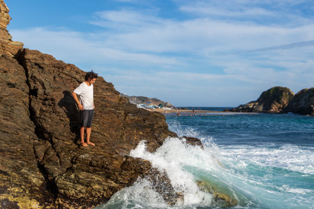 A young male enjoying the beautiful seascape in the sunlightの写真素材
