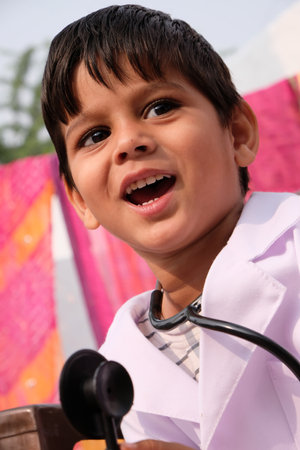 A little Indian boy in white medical uniform with a stethoscopeの写真素材