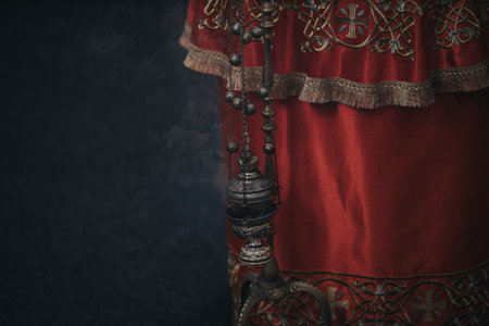 A closeup shot of a thurible by the red velvet fabrics in the churchの写真素材