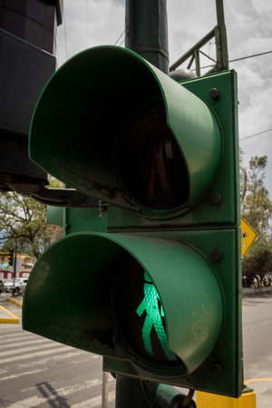 A low-angle shot of the pedestrian's lights showing the green color against the cloudy skyの写真素材