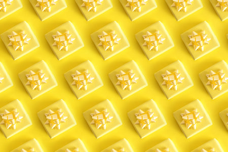A top view shot of pattern small yellow gift on pastel yellow backgroundの写真素材