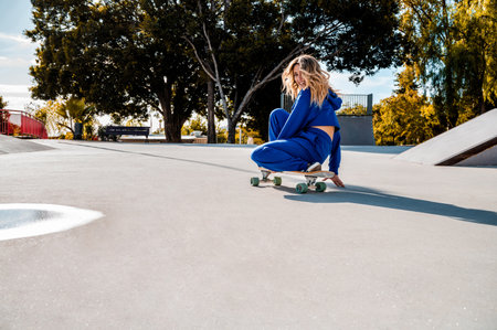 A cool attractive girl doing trick on a skateboard in the skateparkの写真素材