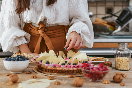 A female decorating a homemade cheesecake with berriesの写真素材