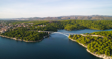 Bridge on croatian coast, aerial drone view of traffic on a road between the Brodarica town and Zaboric village, golden hour ,Croatiaの写真素材