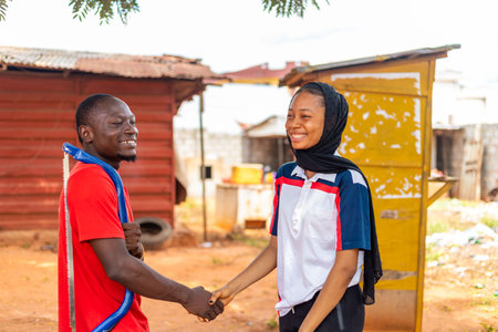 An African carpenter smiling as he shakes his the hand of his clientの写真素材