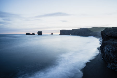 A scenic shot of the black sand Reynisfjara Beach in Vik, Icelandの写真素材