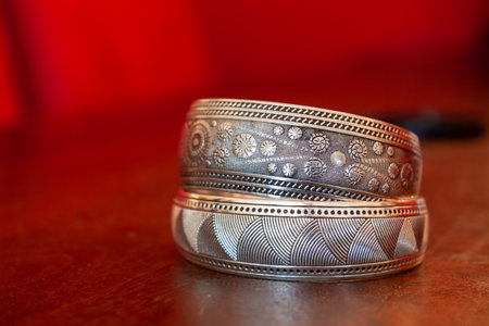 A selective focus shot of silver jewelry on red background
