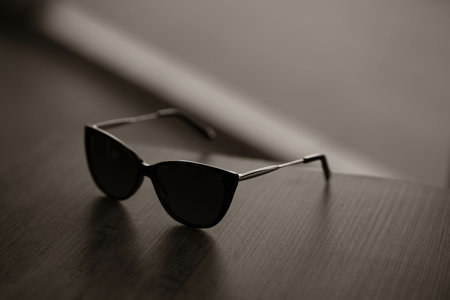 A closeup shot of brown wayfarer style sunglasses on a wooden tableの写真素材