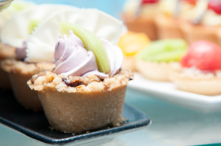A closeup shot of basket cakes decorated with colorful creams on the platesの写真素材