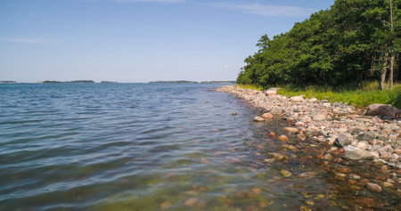 Aerial drone view low, close to the sea surface, on the rocky coast of Hogsara island, on the Gulf of Finland, sunny, summer day, in Varsinais-suomi,の写真素材