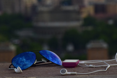 A soft focus of sunglasses, mp3 player and earphones on a concrete surface - jogging, exercise conceptの写真素材