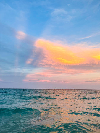 A mesmerizing view of a partially rough sea under a beautiful sunset skyの写真素材