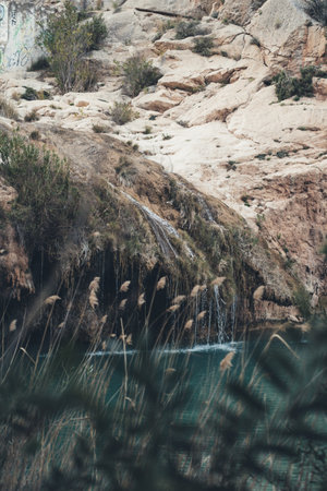 A scenic shot of the water flowing from rocky bank to the turquoise water in a riverの写真素材