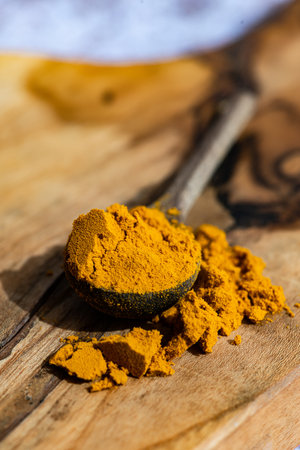 Ground organic turmeric in wooden spoonの写真素材