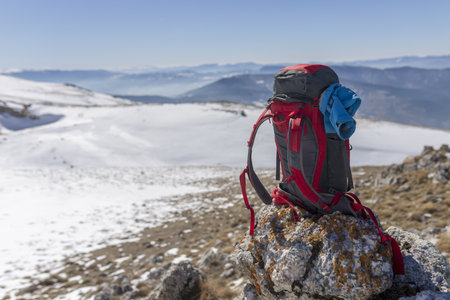 A back view of a hiker looking at the view from a snowy mountain peak