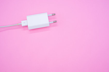 A closeup shot of USB charger with cord isolated on pink backgroundの写真素材