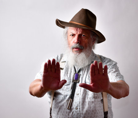 A senior Caucasian bearded male showing stop gesture on white backgroundの写真素材