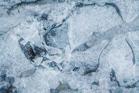 A closeup shot of Frozen puddle, broken ice textureの写真素材
