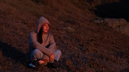 young woman watching a sunset meditating on a cold day on the coast of Chile, copy spaceの写真素材
