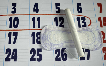A closeup shot of a marker and a sanitary napkin on a calendar - monthly menstruation conceptの写真素材