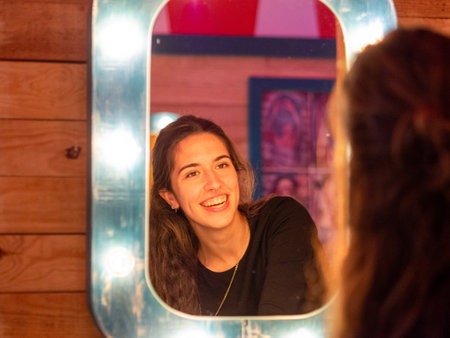 A shot of a young Caucasian girl from Spain looking in the mirrorの写真素材