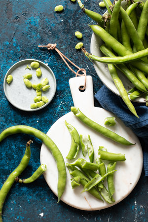 A top view of ripe fresh green peas on a white plateの写真素材
