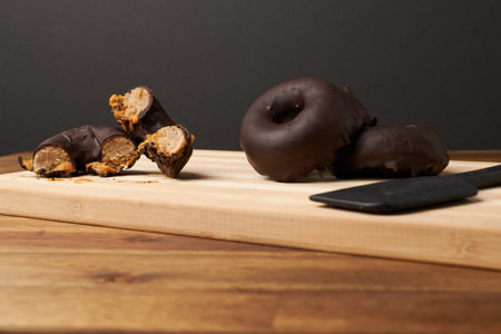 A closeup of chocolate donuts on a wooden boardの写真素材