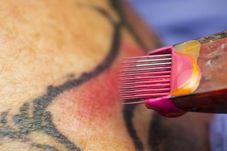 A macro shot of a tattoo machine doing a tattoo on the skinの写真素材