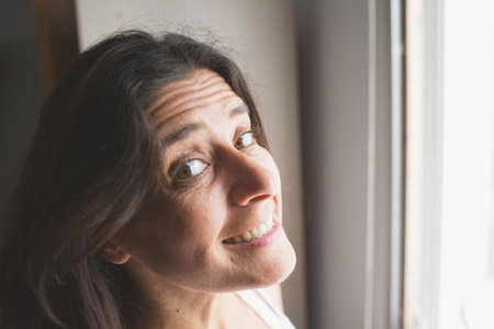 A shallow focus of a Hispanic woman looking at the camera with a smiling faceの写真素材
