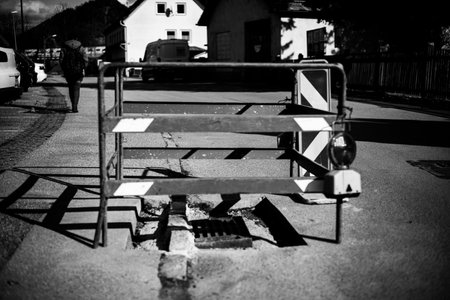 A black and white shot of a construction site in the streetの写真素材
