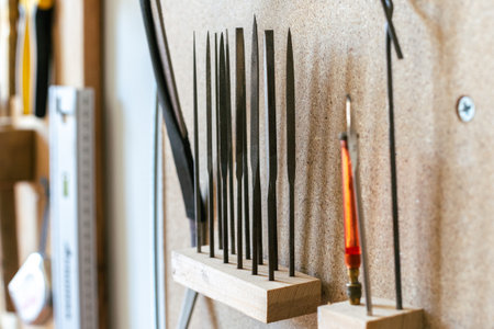 A group of fine metal rasps set in wooden holder in the luthier's workshopの写真素材