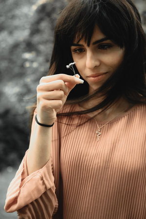 A beautiful Caucasian female holding a small flower