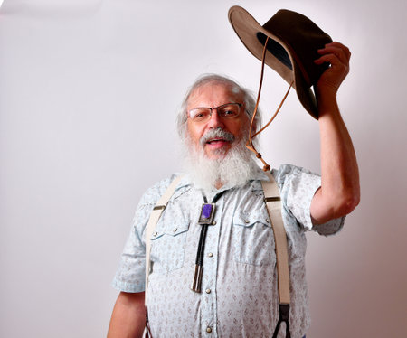 A senior Caucasian bearded gentleman greeting with his hatの写真素材