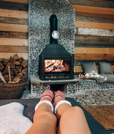 A vertical shot of girl legs in socks near a fireplace at homeの写真素材