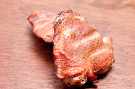 A closeup shot of smoked chicken breast on a wooden tableの写真素材