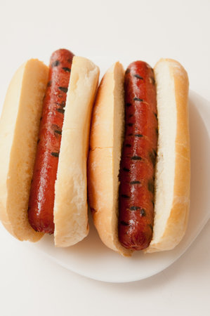 A top view of two tasty hotdogs on a plate in the white backgroundの写真素材