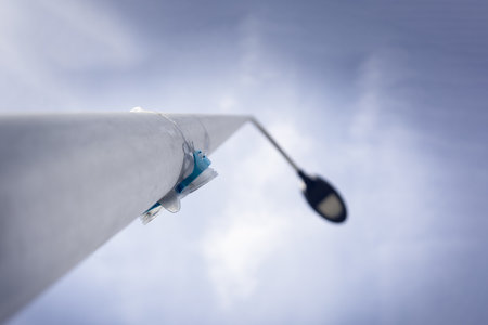 A low angle shot of diving goggles on a lamppost under the sunlight and a cloudy skyの写真素材