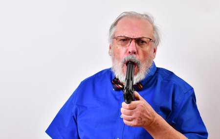 Old male with blue shirt and bow tie committing suicide with his gunの写真素材