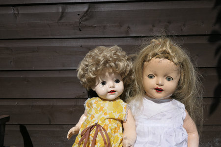 A closeup of creepy old dolls on wooden backgroundの写真素材