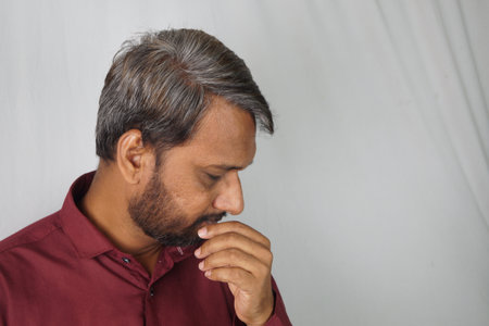 An Indian man worried about white hair and hair loss problem at a young ageの写真素材