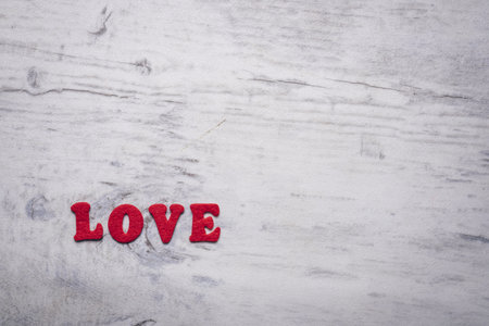 An inscription "Love" written with red felt letters in the gray background with copy spaceの写真素材
