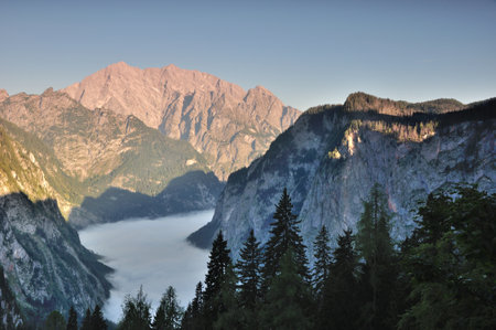 Morning fog over lake Koenigssee and Obersee, Mt. Watzmann with its famous east face in the back, bavarian alps, Germanyの写真素材