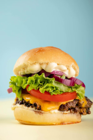 A vertical shot of a hamburger on an isolated colored backgroundの写真素材